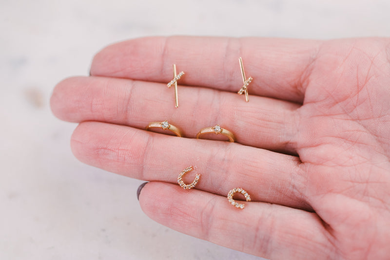 hand holding gold and diamond earrings