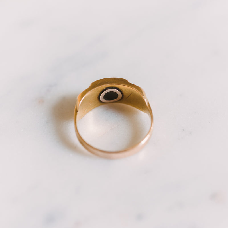 the backside of a gold and onyx ring