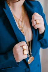 woman wearing lots of jewelry grasping her lapel