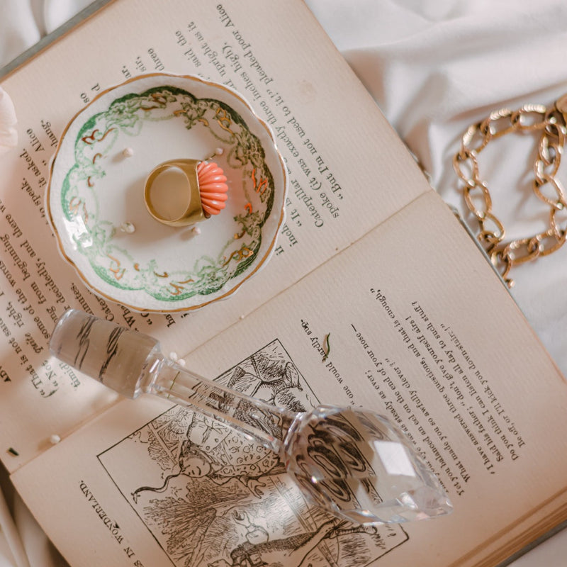 a ring sits on a small ring dish atop an open book