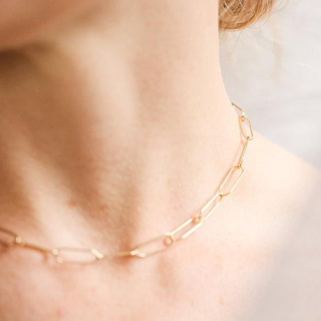 woman wearing gold paper clip chain necklace