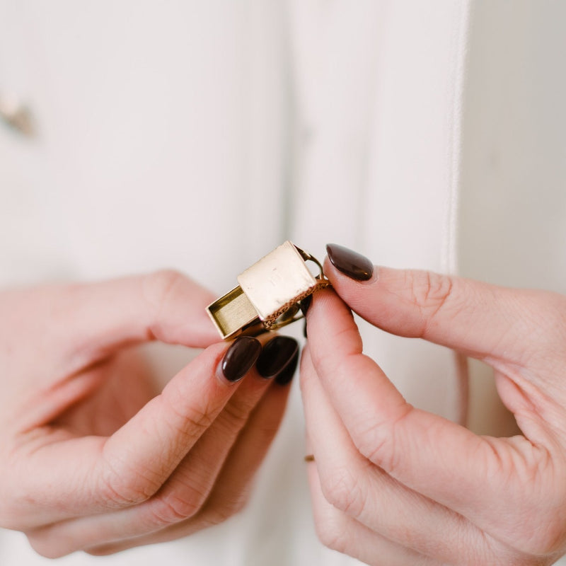 woman holding solid brass ring with compartment