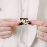 woman holding solid brass ring with compartment