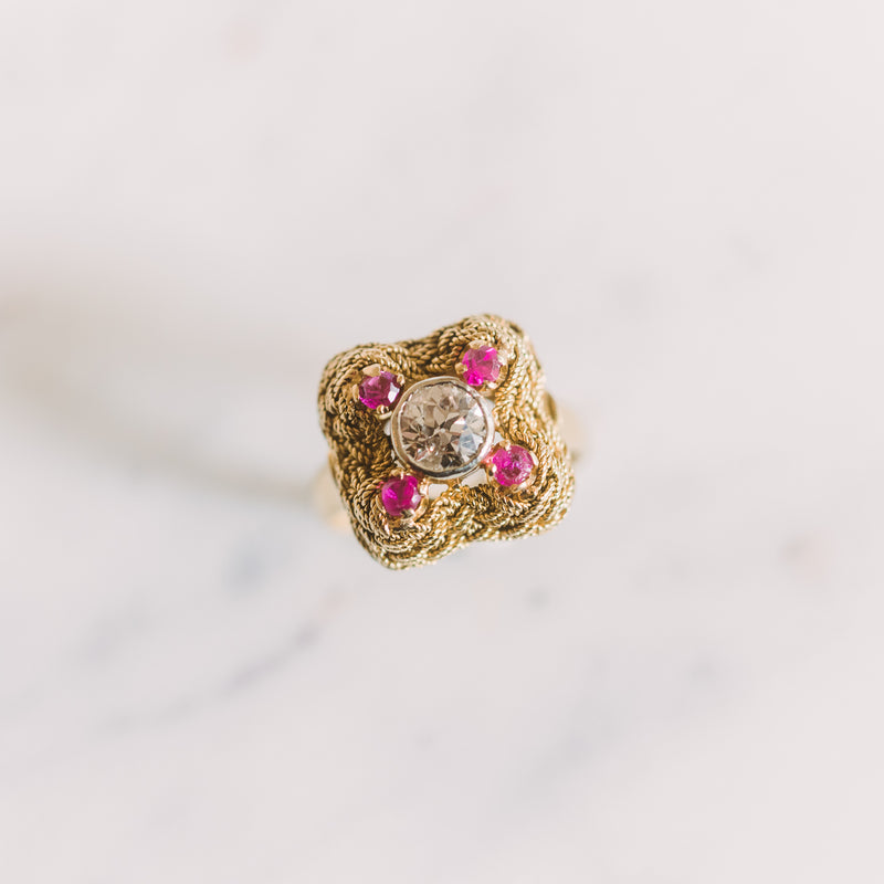 gold ring with a center diamond and four rubies