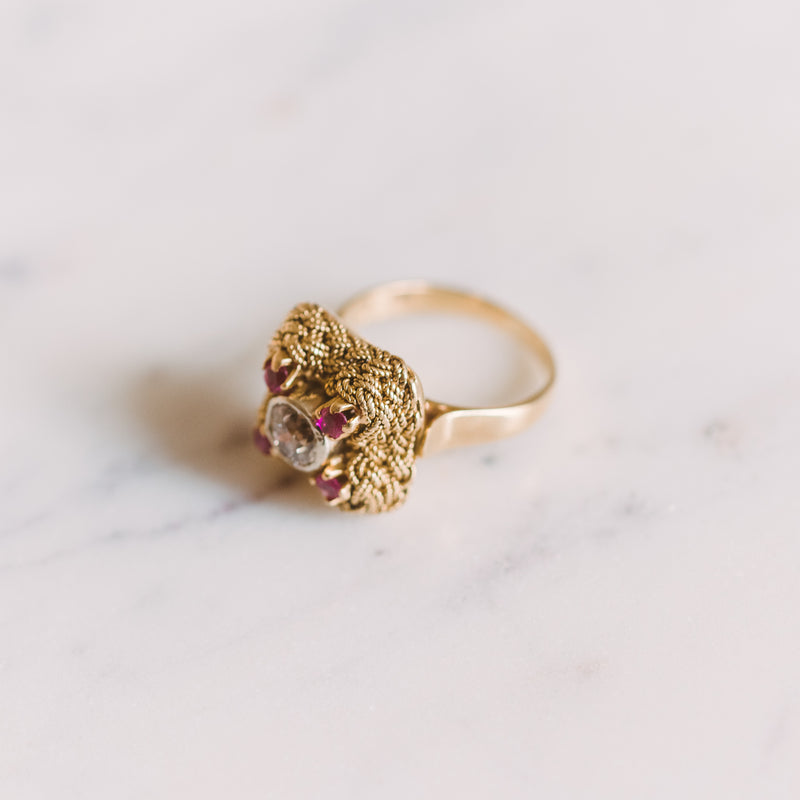 gold ring with a center diamond and four rubies