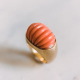 gold dome ring with a carved piece of coral in the center