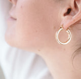 ear wearing chunky gold hoops