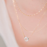 woman wearing layered necklaces