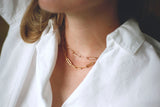 woman wearing two gold paper clip chain necklaces